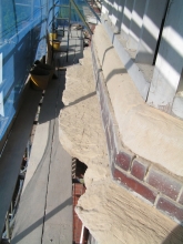 Clean out old stone repairs and loose material from balcony cornice